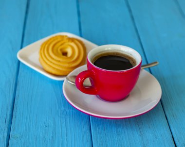 Espresso kahve parlak pembe porselen fincan ve bir tabak kurabiye