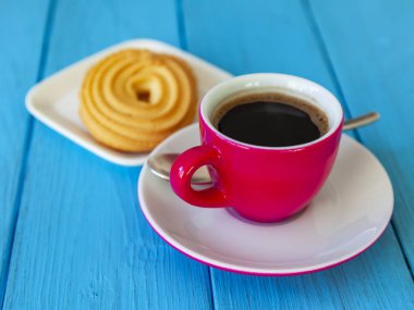 Espresso kahve parlak pembe porselen fincan ve bir tabak kurabiye