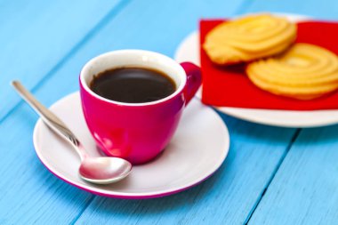 Espresso kahve parlak pembe porselen fincan ve bir tabak kurabiye