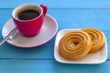 Espresso kahve parlak pembe porselen fincan ve bir tabak kurabiye