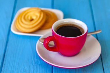 Espresso kahve parlak pembe porselen fincan ve bir tabak kurabiye