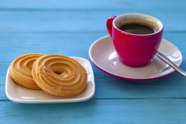 Espresso kahve parlak pembe porselen fincan ve bir tabak kurabiye