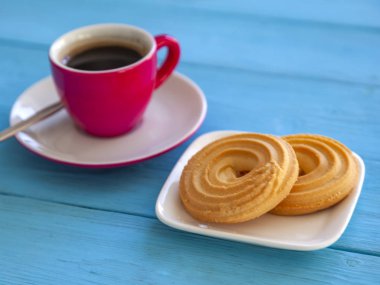 Espresso kahve parlak pembe porselen fincan ve bir tabak kurabiye