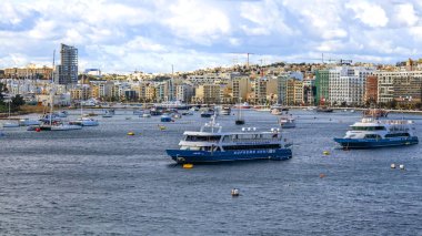 Sliema, Malta, üzerinde 8 Ocak 2019. Pitoresk koyda yürüyen Tekneler güneşin ile kış sabahları yanıyor. Uzaktan güzel dolgu