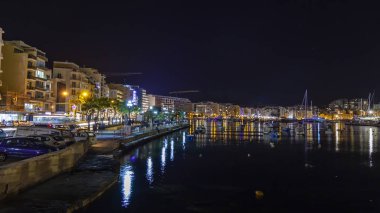 Sliema, Malta, 5 Ocak 2019 tarihinde. Gece bak. defne suya yansıyan akşam yangınlar ile Bay pitoresk setin yaktı