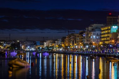 Sliema, Malta, 5 Ocak 2019 tarihinde. Gece bak. defne suya yansıyan akşam yangınlar ile Bay pitoresk setin yaktı