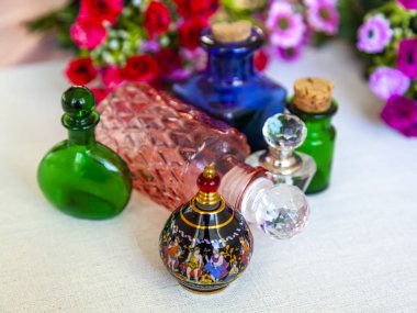 Kozmetik vintage şişeler ve arka plan üzerinde rengarenk çiçekler