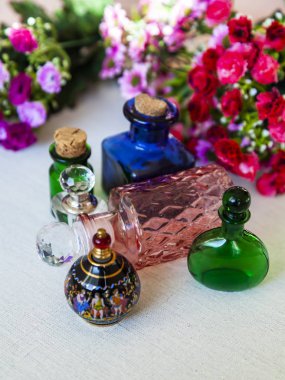 Kozmetik vintage şişeler ve arka plan üzerinde rengarenk çiçekler