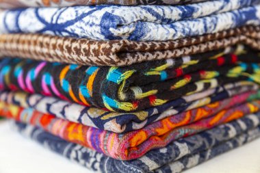 çeşitli renklerde eşarp tezgahın üzerine dizilir