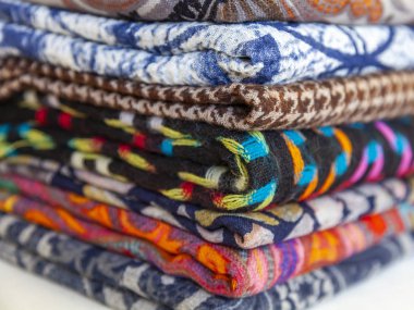 çeşitli renklerde eşarp tezgahın üzerine dizilir