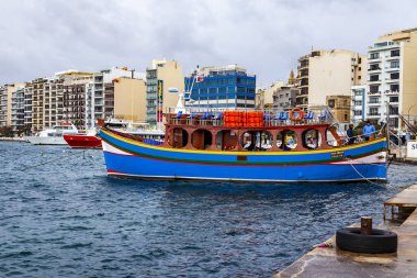 Sliema, Malta, üzerinde 8 Ocak 2019. Pitoresk koyda yürüyen Tekneler güneşin ile kış sabahları yanıyor. Uzaktan güzel dolgu