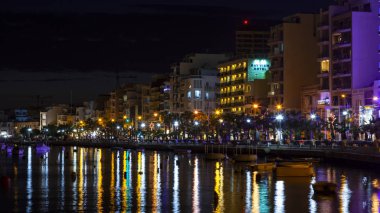 Sliema, Malta, 5 Ocak 2019 tarihinde. Gece bak. defne suya yansıyan akşam yangınlar ile Bay pitoresk setin yaktı