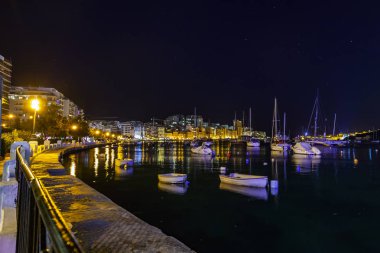 Sliema, Malta, 5 Ocak 2019 tarihinde. Gece bak. defne suya yansıyan akşam yangınlar ile Bay pitoresk setin yaktı
