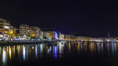 Sliema, Malta, 5 Ocak 2019 tarihinde. Gece bak. defne suya yansıyan akşam yangınlar ile Bay pitoresk setin yaktı