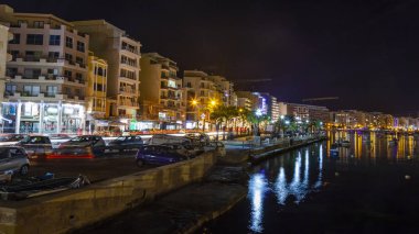 Sliema, Malta, 5 Ocak 2019 tarihinde. Gece bak. defne suya yansıyan akşam yangınlar ile Bay pitoresk setin yaktı