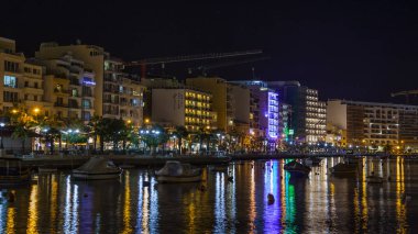 Sliema, Malta, 5 Ocak 2019 tarihinde. Gece bak. defne suya yansıyan akşam yangınlar ile Bay pitoresk setin yaktı