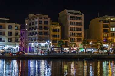 Sliema, Malta, 5 Ocak 2019 tarihinde. Gece bak. defne suya yansıyan akşam yangınlar ile Bay pitoresk setin yaktı