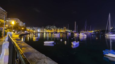 Sliema, Malta, 5 Ocak 2019 tarihinde. Gece bak. defne suya yansıyan akşam yangınlar ile Bay pitoresk setin yaktı