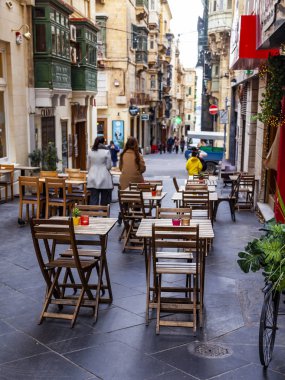 Valletta, Malta, üzerinde 8 Ocak 2019. İnsanlar eski şehrin yoğun alışveriş caddesi boyunca gidin. Masalara sokak Cafe ziyaretçiler için