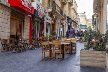 Valletta, Malta, üzerinde 8 Ocak 2019. İnsanlar eski şehrin yoğun alışveriş caddesi boyunca gidin. Masalara sokak Cafe ziyaretçiler için