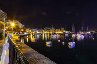 Sliema, Malta, 5 Ocak 2019 tarihinde. Gece bak. defne suya yansıyan akşam yangınlar ile Bay pitoresk setin yaktı