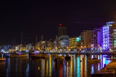 Sliema, Malta, 5 Ocak 2019 tarihinde. Gece bak. defne suya yansıyan akşam yangınlar ile Bay pitoresk setin yaktı