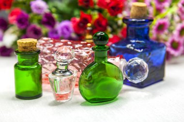 Kozmetik vintage şişeler ve arka plan üzerinde rengarenk çiçekler