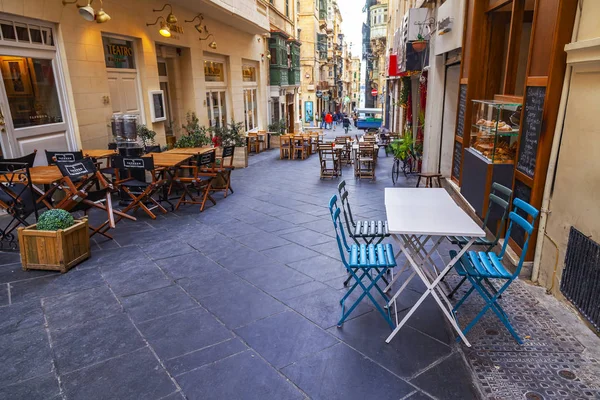 Valletta, Malta, üzerinde 8 Ocak 2019. İnsanlar eski şehrin yoğun alışveriş caddesi boyunca gidin. Masalara sokak Cafe ziyaretçiler için