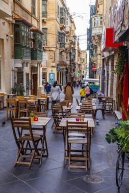 Valletta, Malta, üzerinde 8 Ocak 2019. İnsanlar eski şehrin yoğun alışveriş caddesi boyunca gidin. Masalara sokak Cafe ziyaretçiler için