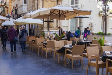 Valletta, Malta, üzerinde 8 Ocak 2019. İnsanlar eski şehrin yoğun alışveriş caddesi boyunca gidin. Masalara sokak Cafe ziyaretçiler için