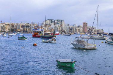 Sliema, Malta, üzerinde 8 Ocak 2019. Pitoresk koyda yürüyen Tekneler güneşin ile kış sabahları yanıyor. Uzaktan güzel dolgu
