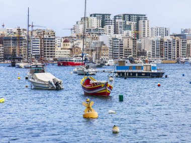 Sliema, Malta, üzerinde 8 Ocak 2019. Pitoresk koyda yürüyen Tekneler güneşin ile kış sabahları yanıyor. Uzaktan güzel dolgu