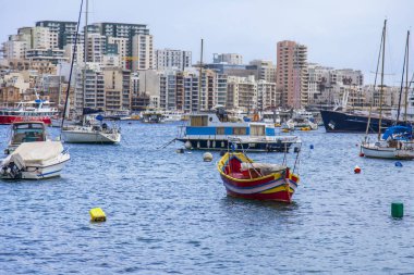 Sliema, Malta, üzerinde 8 Ocak 2019. Pitoresk koyda yürüyen Tekneler güneşin ile kış sabahları yanıyor. Uzaktan güzel dolgu