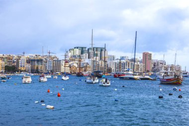 Sliema, Malta, üzerinde 8 Ocak 2019. Pitoresk koyda yürüyen Tekneler güneşin ile kış sabahları yanıyor. Uzaktan güzel dolgu
