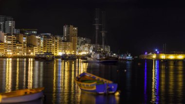Sliema, Malta, 5 Ocak 2019 tarihinde. Gece bak. defne suya yansıyan akşam yangınlar ile Bay pitoresk setin yaktı
