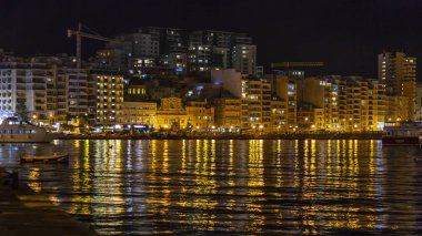 Sliema, Malta, 5 Ocak 2019 tarihinde. Gece bak. defne suya yansıyan akşam yangınlar ile Bay pitoresk setin yaktı