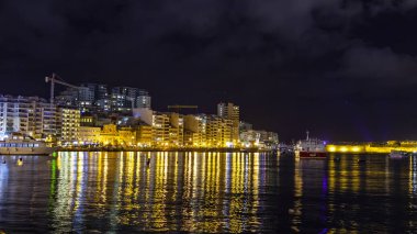 Sliema, Malta, 5 Ocak 2019 tarihinde. Gece bak. defne suya yansıyan akşam yangınlar ile Bay pitoresk setin yaktı