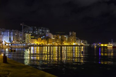 Sliema, Malta, 5 Ocak 2019 tarihinde. Gece bak. defne suya yansıyan akşam yangınlar ile Bay pitoresk setin yaktı