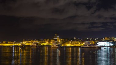 Sliema, Malta, 5 Ocak 2019 tarihinde. Gece bak. defne suya yansıyan akşam yangınlar ile Bay pitoresk setin yaktı