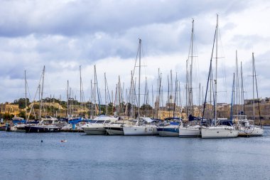 Il-Gzira, Malta, üzerinde 8 Ocak 2019. Yürüyen tekneler ve yatlar pitoresk koyda demirlemiş. Bulutlu hava
