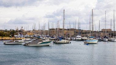Il-Gzira, Malta, üzerinde 8 Ocak 2019. Yürüyen tekneler ve yatlar pitoresk koyda demirlemiş. Bulutlu hava
