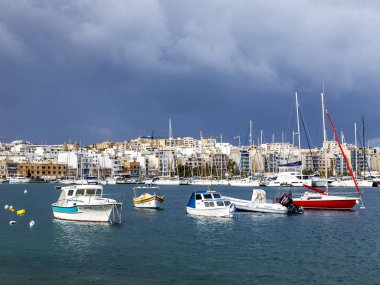 Il-Gzira, Malta, üzerinde 8 Ocak 2019. Yürüyen tekneler ve yatlar pitoresk koyda demirlemiş. Bulutlu hava