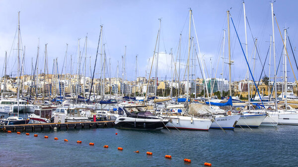 Иль-Гзира, Мальта, 8 января 2019 года. В живописном заливе пришвартованы прогулочные катера и яхты. Облачная погода
