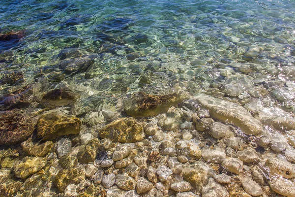 Transparent sea water and stones at the bottom, background