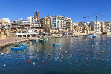 San Giljan, Malta, üzerinde 8 Ocak 2019. Pitoresk koyda yürüyen tekneler güneşin ile kış sabahları yanıyor. Uzaktan güzel dolgu
