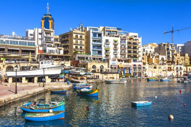 San Giljan, Malta, üzerinde 8 Ocak 2019. Pitoresk koyda yürüyen tekneler güneşin ile kış sabahları yanıyor. Uzaktan güzel dolgu