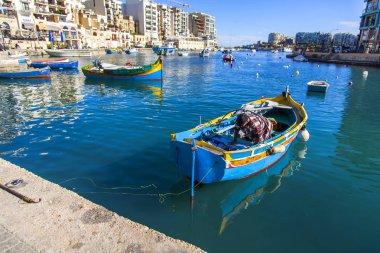 San Giljan, Malta, üzerinde 8 Ocak 2019. Pitoresk koyda yürüyen tekneler güneşin ile kış sabahları yanıyor. Uzaktan güzel dolgu