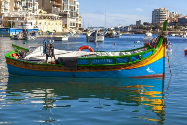 San Giljan, Malta, üzerinde 8 Ocak 2019. Pitoresk koyda yürüyen tekneler güneşin ile kış sabahları yanıyor. Uzaktan güzel dolgu