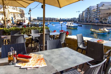 San Giljan, Malta, üzerinde 8 Ocak 2019. Tablolar setin Spinola Körfezi üzerinde pitoresk sokak Cafe