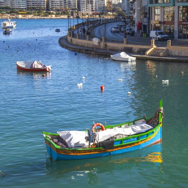 San Giljan, Malta, 7 Ocak 2019 tarihinde. Yürüyüş ve balıkçı tekneleri pitoresk defne Spinola içinde güneşin ile kış sabahları yanıyor. Uzaktan güzel dolgu